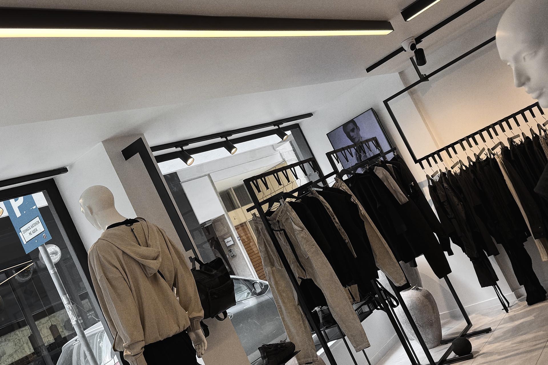 Wide architectural view inside the TEPHRΛ Athens store with clothing rails, lighting and display forms